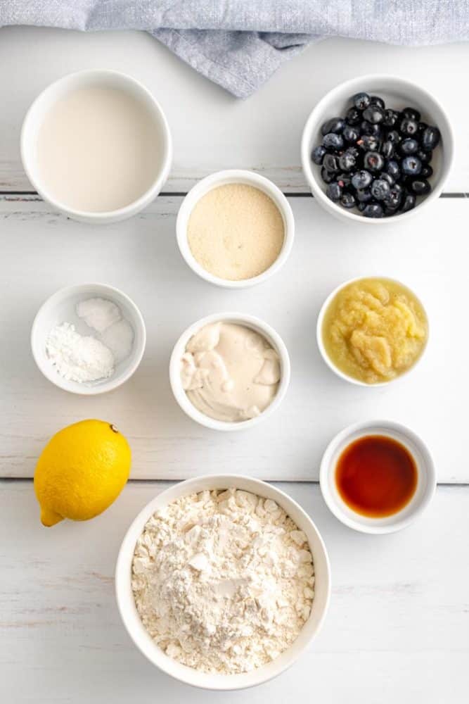 ingredients for lemon blueberry cake in white bowls. 