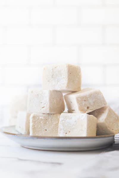 stack of vegan marshmallow cubes on a white plate.
