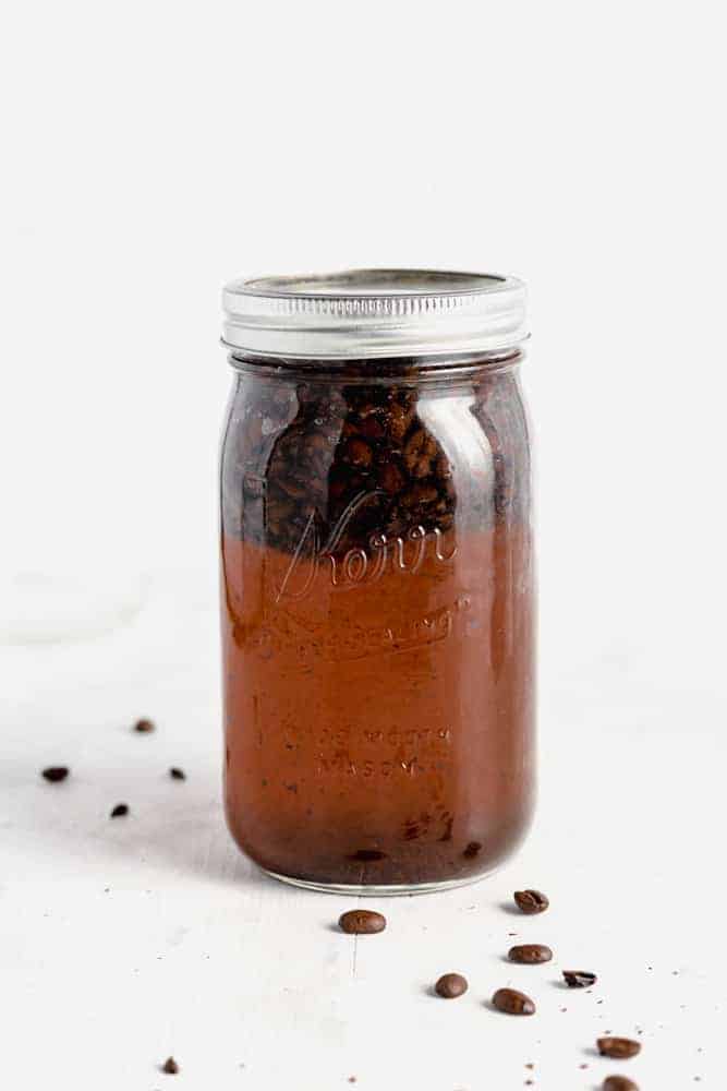 Lidded jar of steeping coffee beans. 