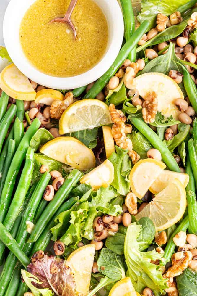 Cold Green Bean Salad with bowl of dressing. 