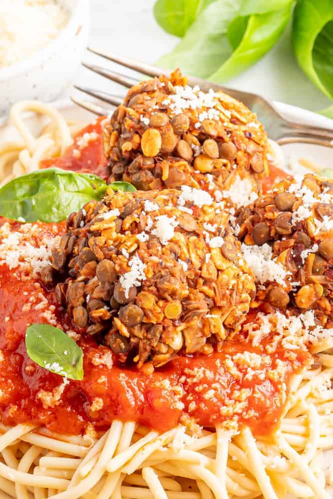 close up shot of meatless meatballs on a plate with a fork. 