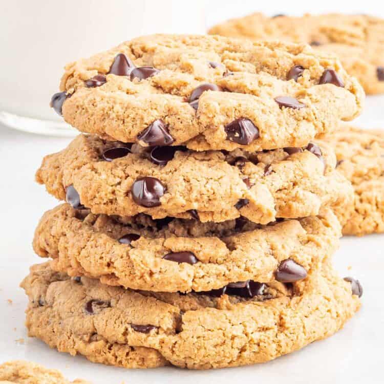 a stack of four vegan chocolate chip cookies on a white background