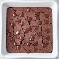 Top view photo of black bean brownies, fully cooked in a white baking dish, and cooling until ready to enjoy.