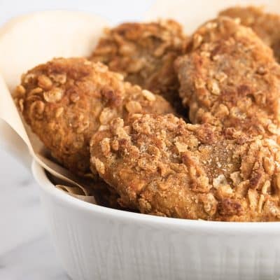 Closeup photo of a white bowl filled with vegan fried chicken, ready to enjoy.