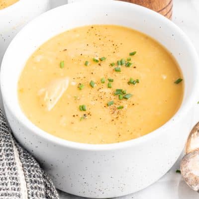 Closeup photo of a bowl of Vegan Potato Soup. The bowl is white.