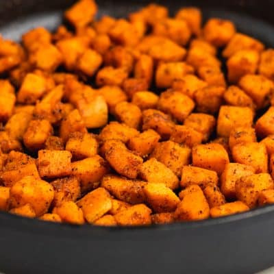 Closeup photo of a cast iron skillet filled with sauteed sweet potatoes.